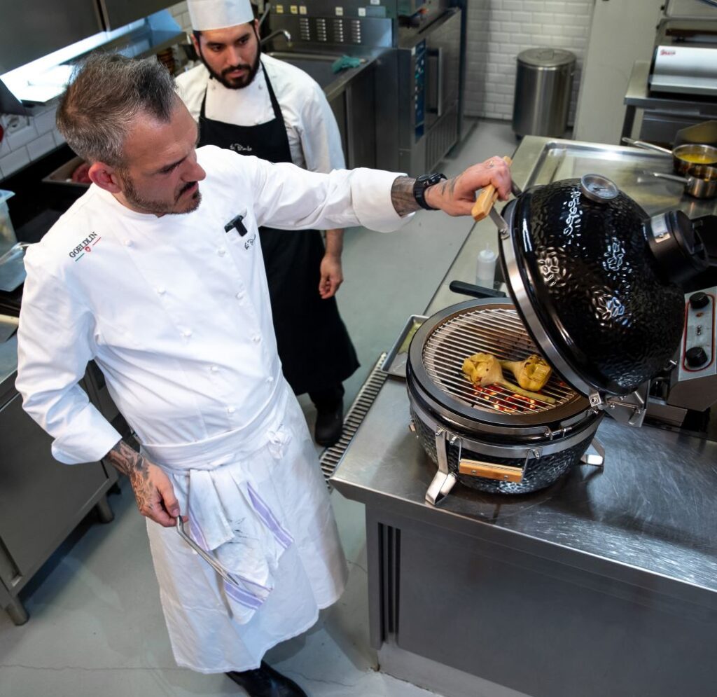 Lo chef roberto di pinto al lavoro sulla cottura alla brace